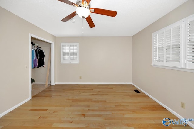 unfurnished bedroom with visible vents, baseboards, a closet, and wood finished floors