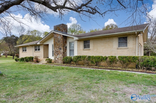 ranch-style home with a chimney, a front lawn, and brick siding