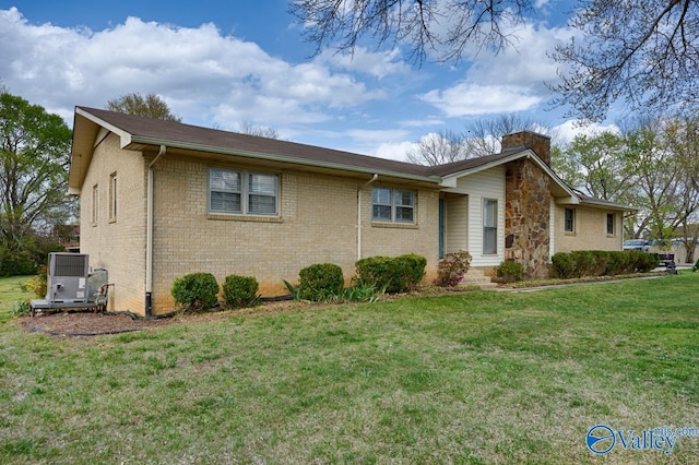 view of side of property featuring brick siding, central air condition unit, a chimney, and a lawn