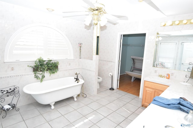bathroom featuring tile patterned floors, toilet, vanity, a bathtub, and ceiling fan