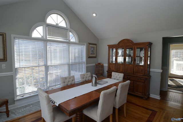 dining area with dark wood-type flooring and high vaulted ceiling