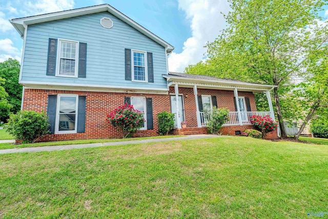split level home featuring brick siding, a front yard, and a porch