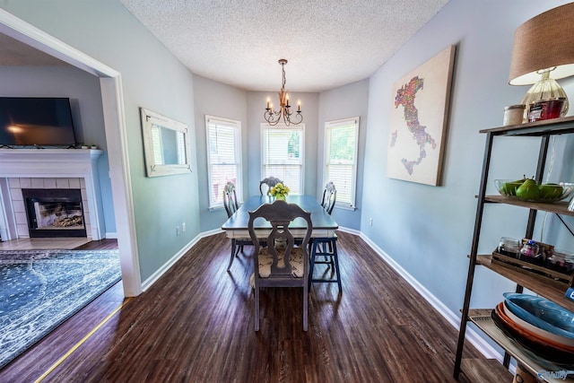 dining room featuring baseboards, a textured ceiling, a chandelier, and dark wood finished floors