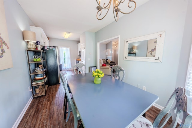 dining area with baseboards, a chandelier, and dark wood-type flooring