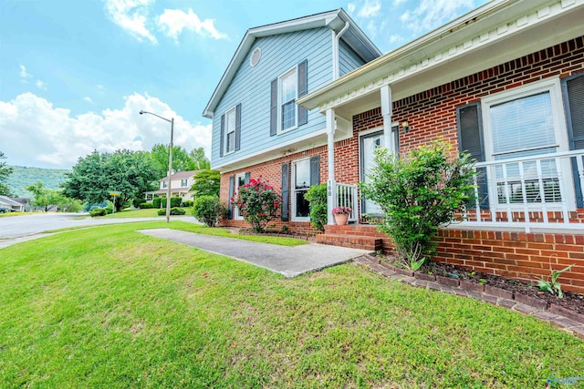 tri-level home featuring brick siding and a front lawn