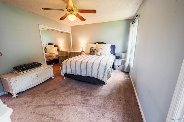bedroom featuring carpet floors, a ceiling fan, a textured ceiling, and visible vents