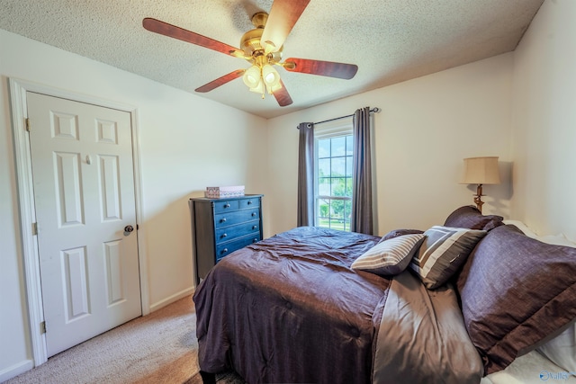 bedroom with baseboards, a textured ceiling, light carpet, and ceiling fan