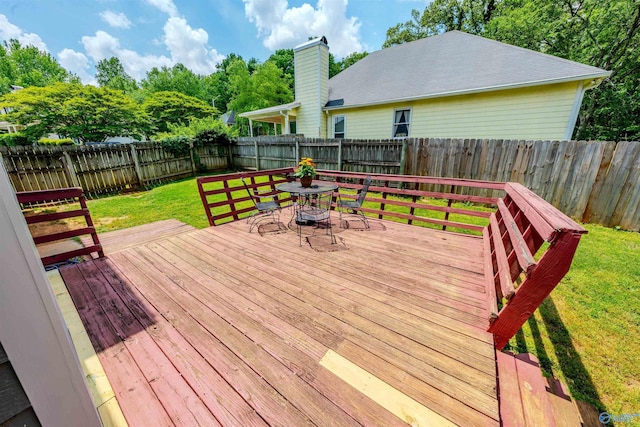 wooden terrace with a fenced backyard, a yard, and outdoor dining space