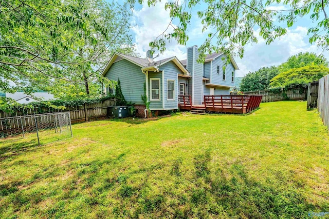 rear view of house with a deck, cooling unit, a fenced backyard, a chimney, and a lawn