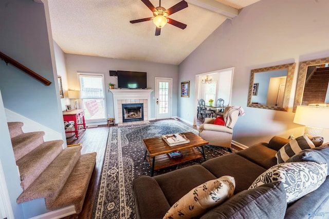 living area featuring stairs, wood finished floors, beam ceiling, baseboards, and ceiling fan