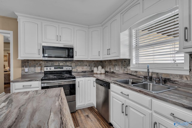 kitchen with sink, stainless steel appliances, dark hardwood / wood-style flooring, decorative backsplash, and white cabinets