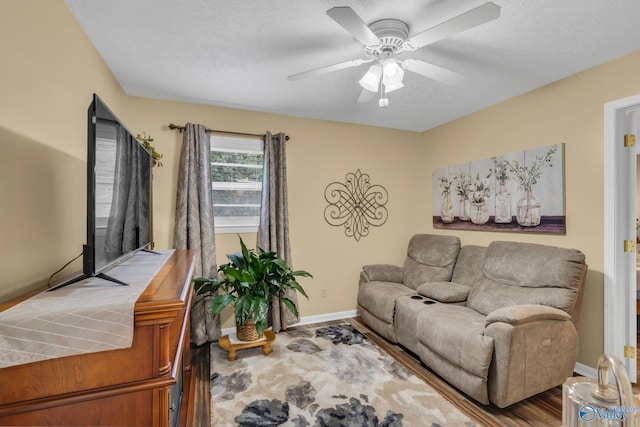 living room with wood-type flooring, a textured ceiling, and ceiling fan