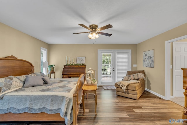 bedroom with hardwood / wood-style floors, access to outside, and ceiling fan