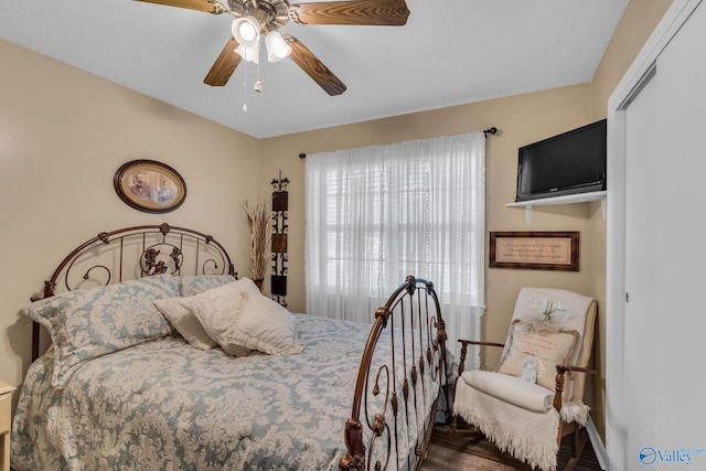 bedroom with ceiling fan, wood-type flooring, and a closet