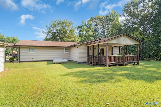 rear view of house with covered porch and a yard