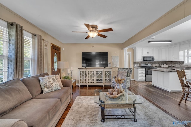 living room with ceiling fan, crown molding, and dark hardwood / wood-style floors