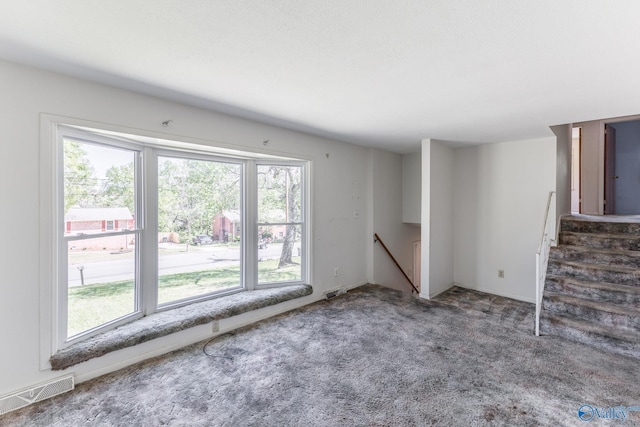 unfurnished living room featuring visible vents and carpet floors