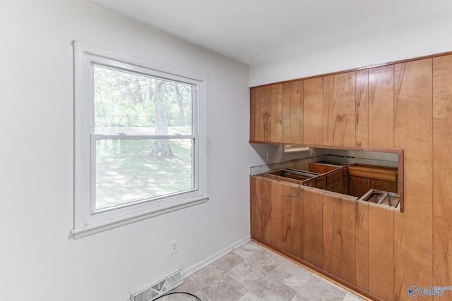kitchen featuring brown cabinetry, visible vents, and baseboards