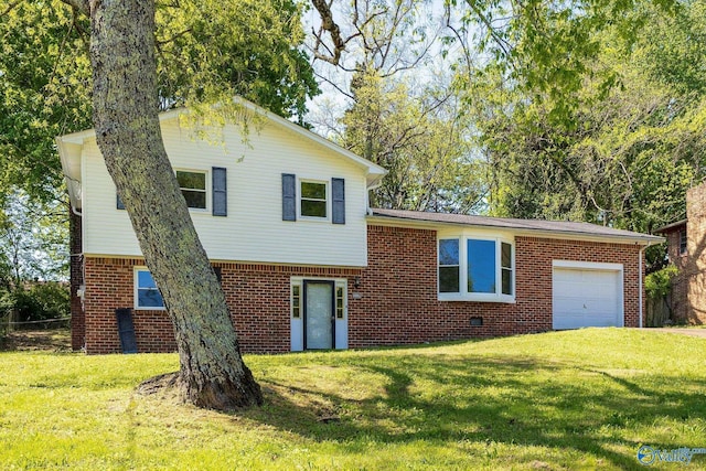 split level home featuring a front lawn, brick siding, and a garage