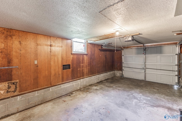 garage featuring wooden walls and a garage door opener