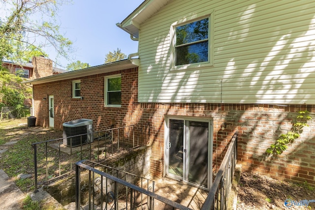 rear view of property with brick siding and cooling unit