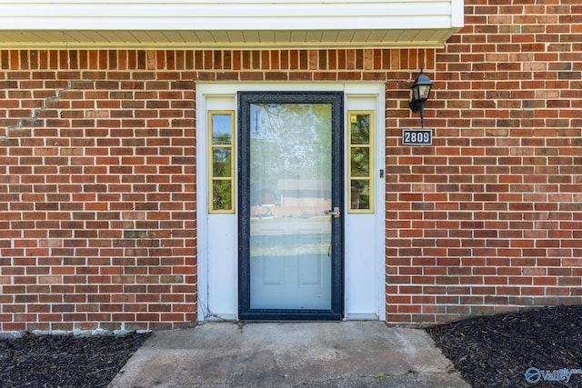 property entrance featuring brick siding