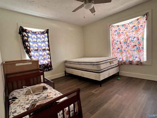 bedroom featuring a textured ceiling, wood finished floors, a ceiling fan, and baseboards