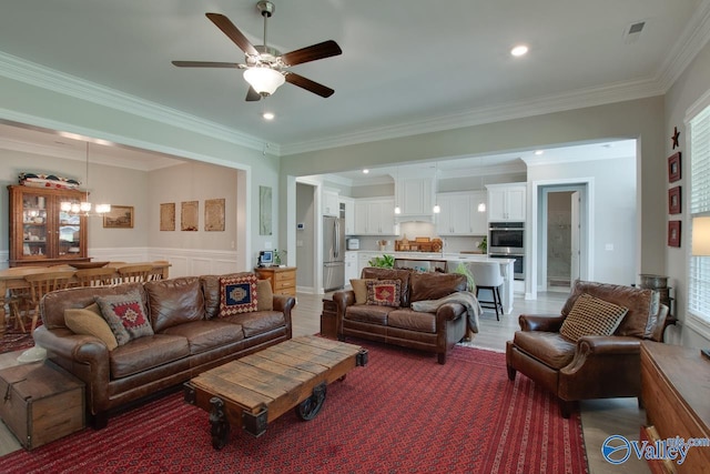 living room featuring ceiling fan with notable chandelier, crown molding, and wood-type flooring