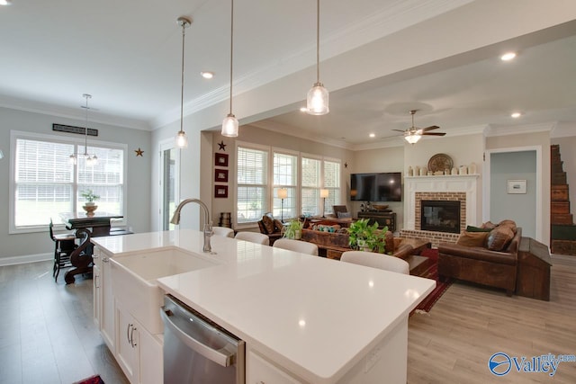 kitchen featuring a center island with sink, dishwasher, and pendant lighting