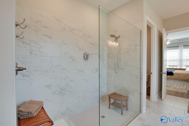 bathroom with ceiling fan, a tile shower, and toilet