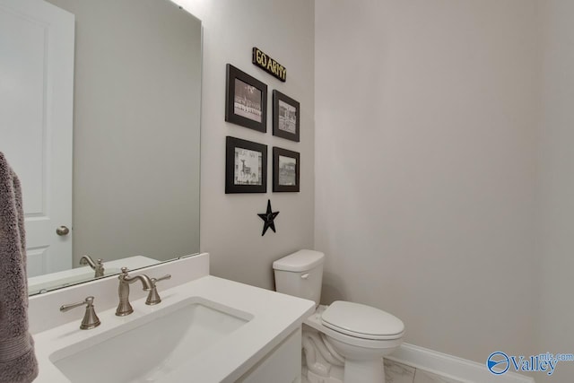 bathroom featuring toilet, vanity, and tile patterned flooring