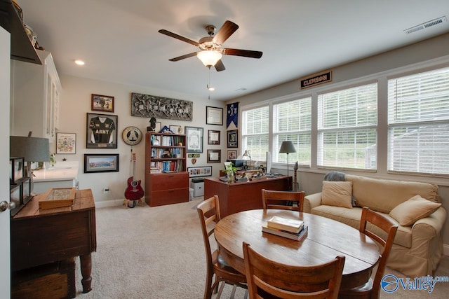 carpeted dining room featuring ceiling fan