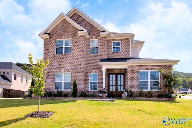 view of front of property featuring a front yard and french doors