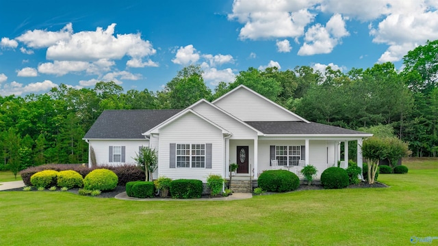 ranch-style home featuring a front lawn and a shingled roof