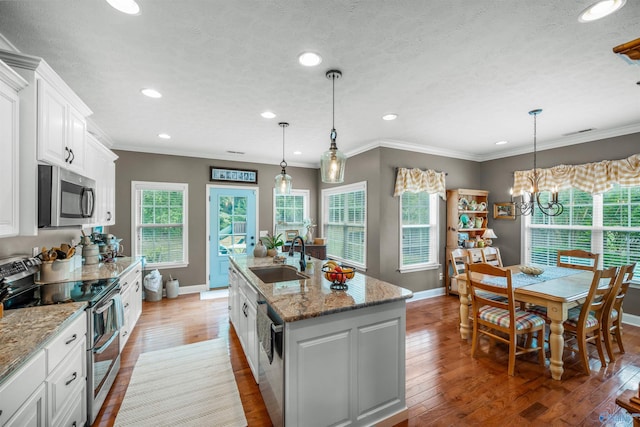 kitchen featuring light wood finished floors, appliances with stainless steel finishes, white cabinetry, and a sink