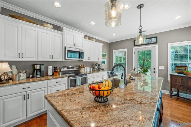 kitchen with crown molding, white cabinets, and appliances with stainless steel finishes