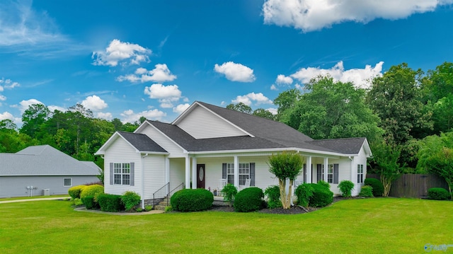 view of front facade featuring roof with shingles, a porch, a front yard, and fence