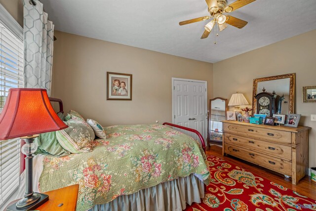 bedroom with a closet, wood finished floors, and a ceiling fan