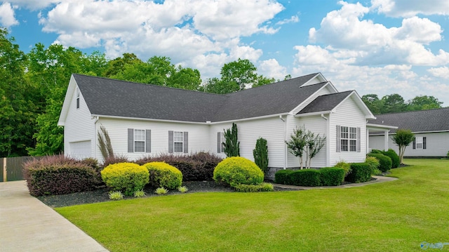 view of front of property with a garage, a front lawn, and a shingled roof