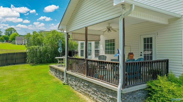 wooden terrace with a lawn, a ceiling fan, and fence