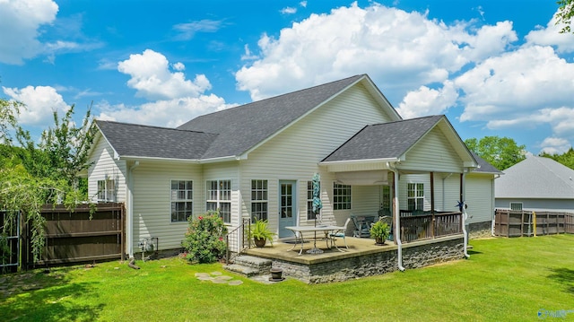 rear view of house featuring a patio, a yard, fence, and a shingled roof