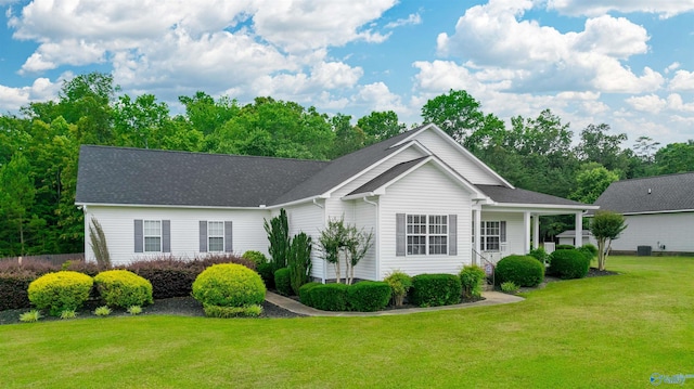 ranch-style home with a front yard and roof with shingles