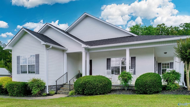 view of front of property with a porch, a front lawn, and a shingled roof