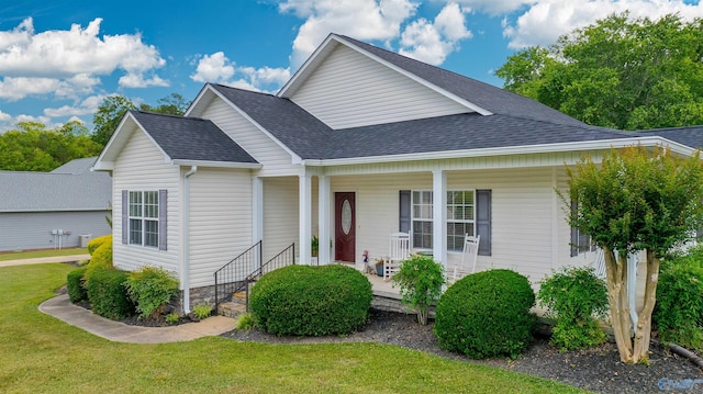 view of front of home featuring a porch, a front lawn, and roof with shingles