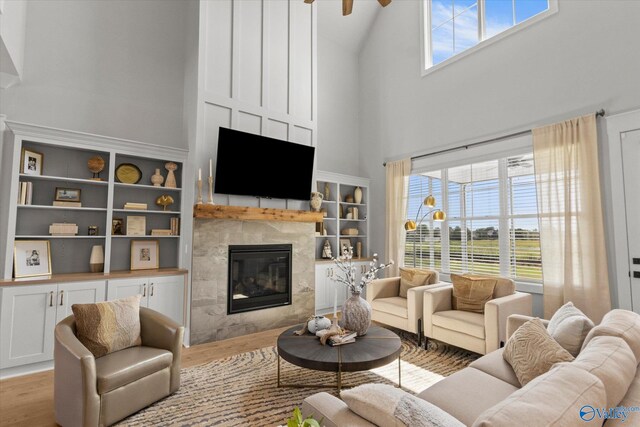 living room featuring light hardwood / wood-style floors, high vaulted ceiling, and a fireplace