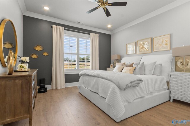 bedroom featuring ceiling fan, ornamental molding, and light hardwood / wood-style floors