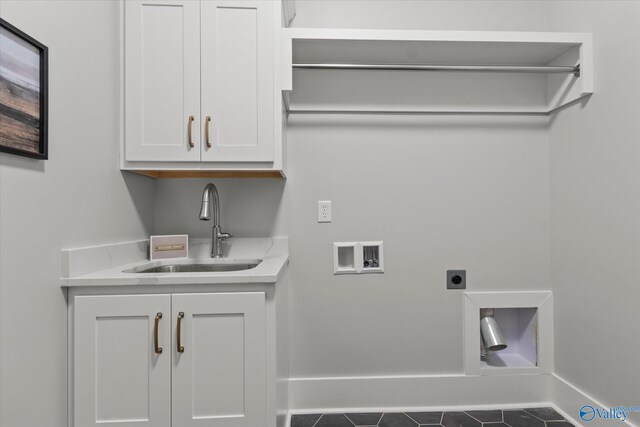 laundry room featuring cabinets, dark tile patterned flooring, washer hookup, sink, and hookup for an electric dryer