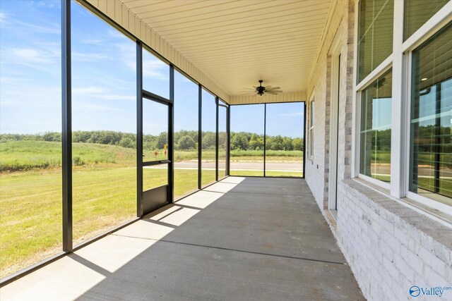 unfurnished sunroom featuring a healthy amount of sunlight and ceiling fan