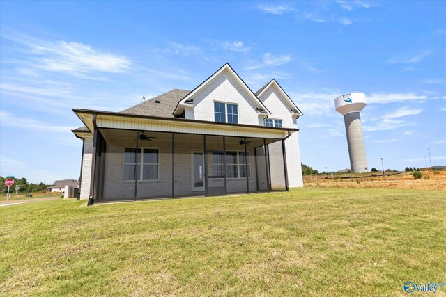 back of property featuring a yard and ceiling fan