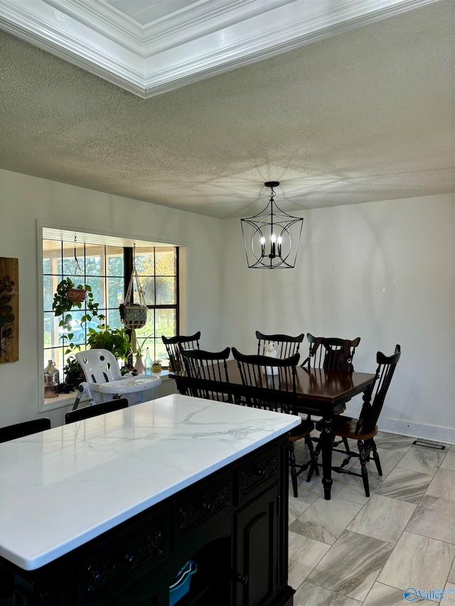 kitchen featuring pendant lighting, a notable chandelier, crown molding, and a textured ceiling